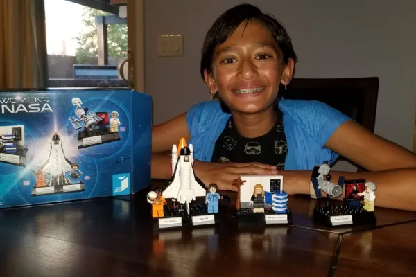 Girl smiling with LEGO NASA set