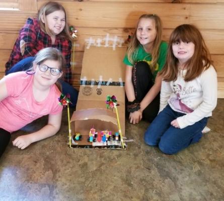 Four girls with a cardboard ramp