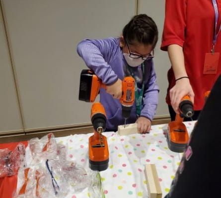 Girl using orange power drill