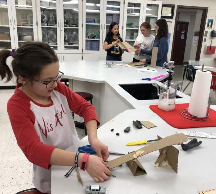 Girl building a ramp out of cardboard