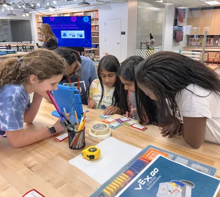 Group of teen girls looking at cards around a table