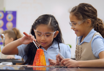 Girls building volcano model