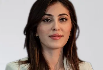 Gulan Gawdan headshot - woman with long dark hair wearing tan blazer