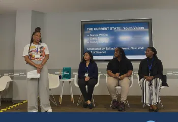 Take Action - Photo of 4 people on a small stage in front of a screen