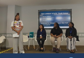 Take Action - Photo of 4 people on a small stage in front of a screen