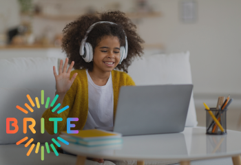 Girl raising her hand while looking at a laptop