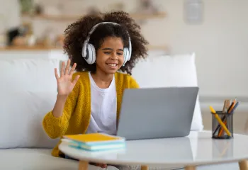 girl with headphones in front of a laptop