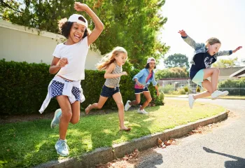 Group of children jumping off a curb