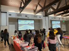 Group of girls watching a video on a large screen. The screen says, "Reminding women they have no limits"