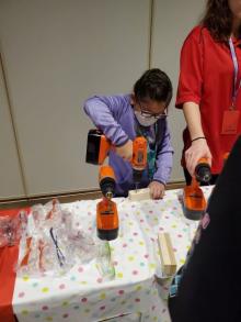 Girl using orange power drill