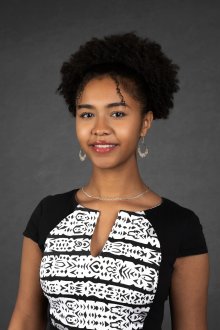 Jamora Arroyo Jefferson - photo of young woman with curly black hair wearing a black and white top