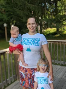 Sara with her two daughters. Wearing tshirts that say "Nevertheless science persisted."