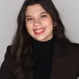 Young woman with long dark hair wearing black shirt and black blazer